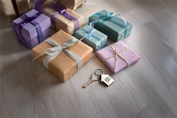 Wrapped housewarming gifts with house key on table