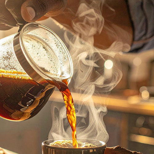 Pouring hot coffee into a phase-change travel mug, keeping coffee at the perfect temperature, with steam rising in golden morning light