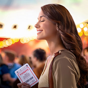 Woman smiling during a hot air balloon ride with sunrise in the background, representing unforgettable experience gifts for women.